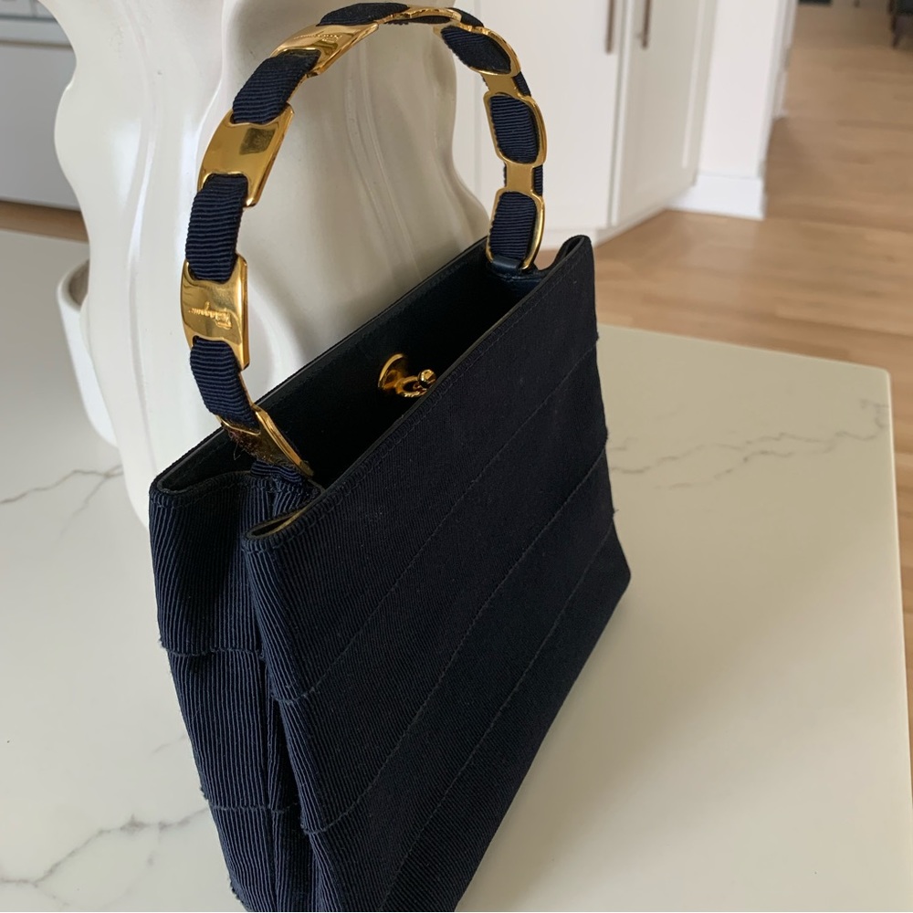 Navy blue Ferragamo fabric bag with beautiful gold signature handle.